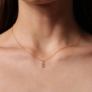 Gold plated stainless steel necklace with diamond-set S letter pendant on neck