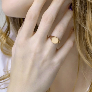 Close-up of a polished rose gold geometric signet ring worn by a model for a sleek look