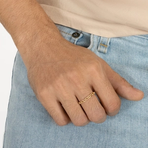 Detailed view of a gold-plated stainless steel chain ring worn on a model's finger