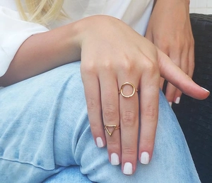 Detail view of gold geometric hollow rings on model with casual styling