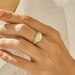 Détail macro d'une bague croissant dorée avec des rayures polies sur un doigt