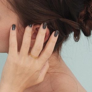 Close-up of gold plated stainless steel chain ring with oval cut finish on model