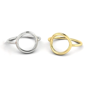 Flat lay of minimalist gold and silver hollow geometric rings on a gray surface
