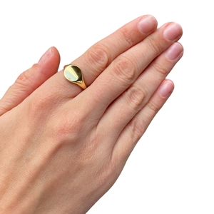 Minimalist gold signet ring for pinky finger with polished round surface and sleek design