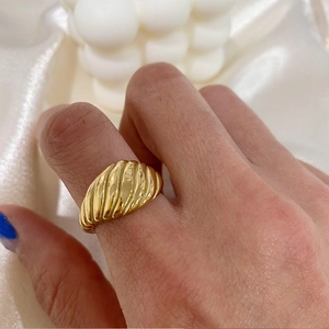 Détail macro de la bague croissant dorée montrant sa texture torsadée et son fini poli