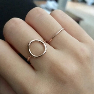 Detail of rose gold minimalist geometric ring set with hollow circle design on hand