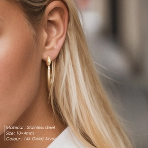 Close-up of minimalist 14k gold teardrop stud earring made of polished stainless steel