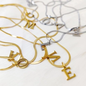 Collares de cadena de serpiente en oro y plata con varios colgantes de letras iniciales