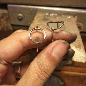 Detailed macro view of minimalist hollow geometric rings in polished stainless steel