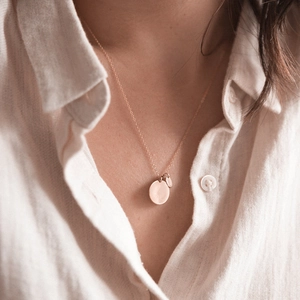 Rose gold stainless steel double round pendant necklace worn on a linen shirt
