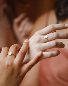 Polished gold stainless steel oval ring shown on model hands for a stacked look
