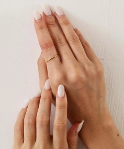 Close-up of minimalist gold plated stainless steel thin ring worn on model's finger