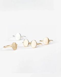 Macro view of minimalist oval signet rings in gold and silver polished finishes