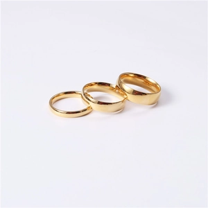 Detailed view of three stackable gold polished stainless steel rings in varying widths