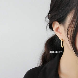 Close-up of polished gold rectangular hoop earrings worn by a model for a commute look