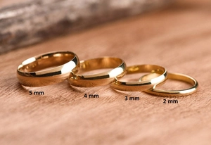 Detail showing 5mm to 2mm widths of minimalist polished gold stainless steel rings