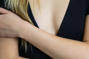 Close-up of a minimalist silver layered chain bracelet on a woman's wrist