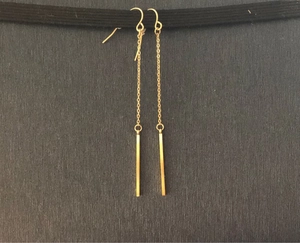 Detailed view of long gold-plated stainless steel chain earrings with slim metal bars