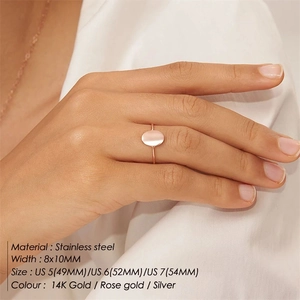 Detail showing an oval gold stainless steel signet ring worn on a finger for daily style