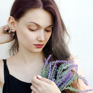 Silver round earrings with white zircon pendant shown worn on model with lavender