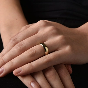 Close-up of polished gold-plated stainless steel band ring worn on model hands