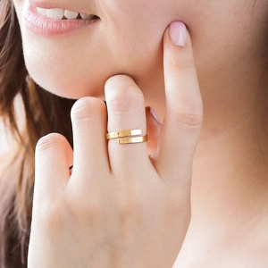 Dettaglio ravvicinato di un anello avvolgente minimalista in acciaio inossidabile dorato