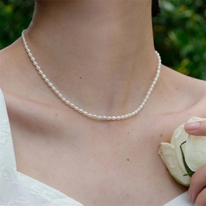 Gros plan d'un collier en acier inoxydable minimaliste avec petites perles sur mannequin