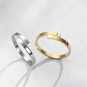 Vista macro di anelli aperti minimalisti in oro e argento con design geometrico
