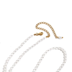 Détail d'un collier de perles ovales blanches avec fermoir mousqueton doré chic