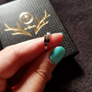 Primo piano di un anello geometrico aperto in acciaio inossidabile argento sul dito