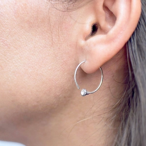 Minimalist round stainless steel earrings with sparkling white cubic zirconia on model