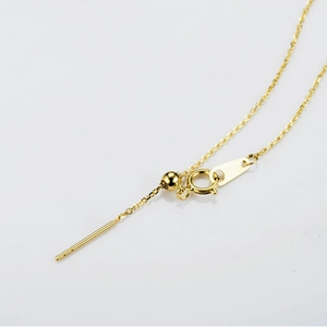 Macro shot of adjustable gold stainless steel jewelry chain with sliding bead and needle end