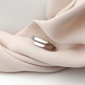 Anello aperto geometrico minimalista in finitura argento lucido su chiffon rosa