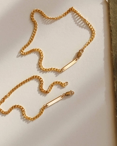 Detailed close-up of gold-plated stainless steel Cuban link chains with lobster clasps