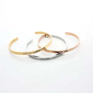 Detailed view of polished stainless steel C-shaped cuff bracelets with custom engraving