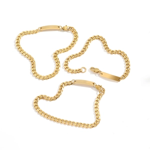 Three gold Cuban chain bracelets with ID plates arranged in a heart shape on white background