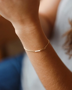 Close-up of a gold-plated stainless steel bar bracelet with a sleek lobster clasp