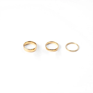 Three-piece set of minimalist polished gold stainless steel rings in varying widths