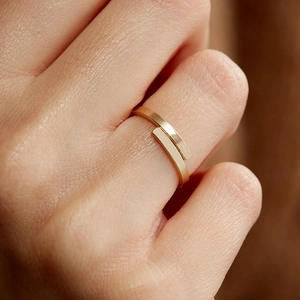 Dettaglio ravvicinato di un anello d'oro minimalista con finitura spazzolata opaca raffinata