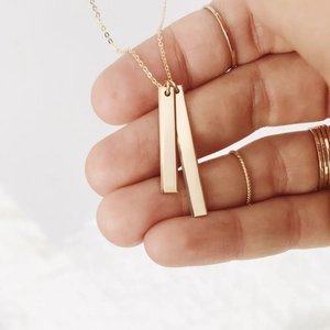 Detail of double rectangular bar pendants on a dainty gold-plated stainless steel chain
