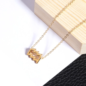 Détail d'un pendentif signe du zodiaque Verseau doré sur une fine chaîne maille