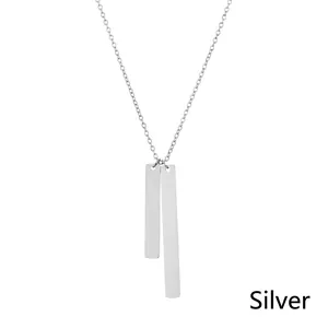 Macro shot of a silver geometric rectangular double bar pendant on a thin link chain