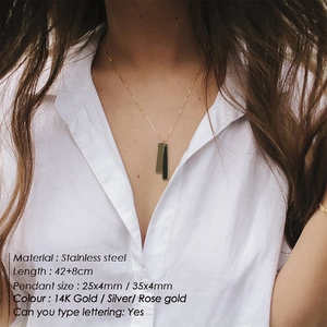 Model wearing gold double bar pendant necklace in stainless steel with custom engraving