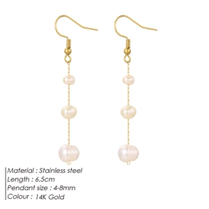 Détail de boucles d'oreilles à pompons dorées 14K avec trois perles naturelles