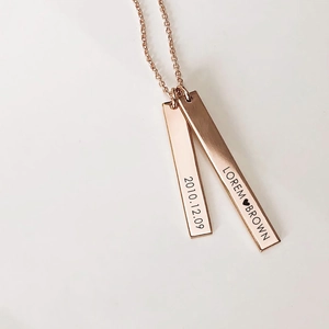 Close-up of personalized rose gold necklace with engraved double rectangular bar pendants