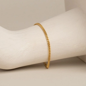 Minimalist 14k gold plated Cuban chain bracelet displayed on a white hand sculpture