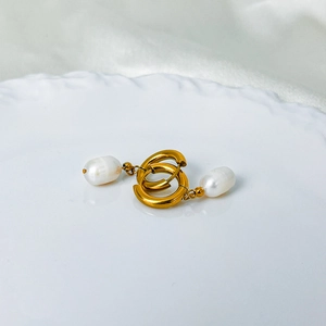 Detail of 14K gold plated double hoop earrings with natural white baroque pearls on silk