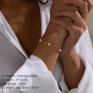 Detailed shot of 5mm pearls on a 14K gold stainless steel chain worn by a model