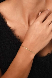 Close-up of minimalist 14k gold-plated Cuban link bracelet on a woman's wrist