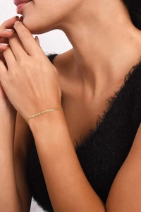 Detail shot of a refined 14k gold plated stainless steel thin chain bracelet on wrist